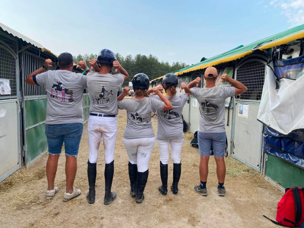 Équipe d’équitation portant des T-shirts personnalisés avec photos de chevaux lors d’un concours hippique