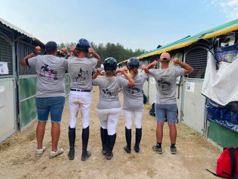 Équipe d’équitation portant des T-shirts personnalisés avec photos de chevaux lors d’un concours hippique