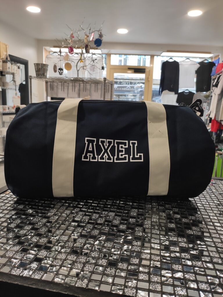 Sac de sport noir personnalisé avec le prénom Axel en lettres blanches
