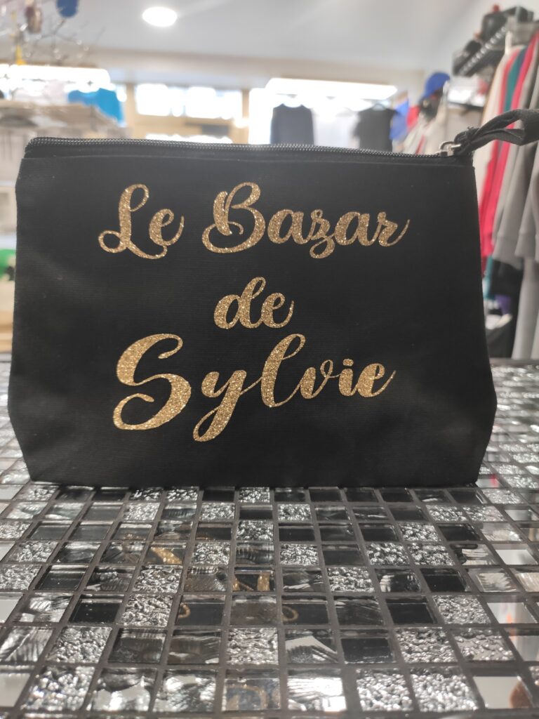 Trousse noire personnalisée avec l’inscription dorée pailletée « Le Bazar de Sylvie »